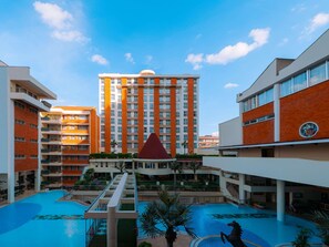 Una piscina al aire libre, sombrillas, tumbonas