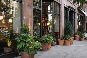 A building with large windows and potted plants outside.