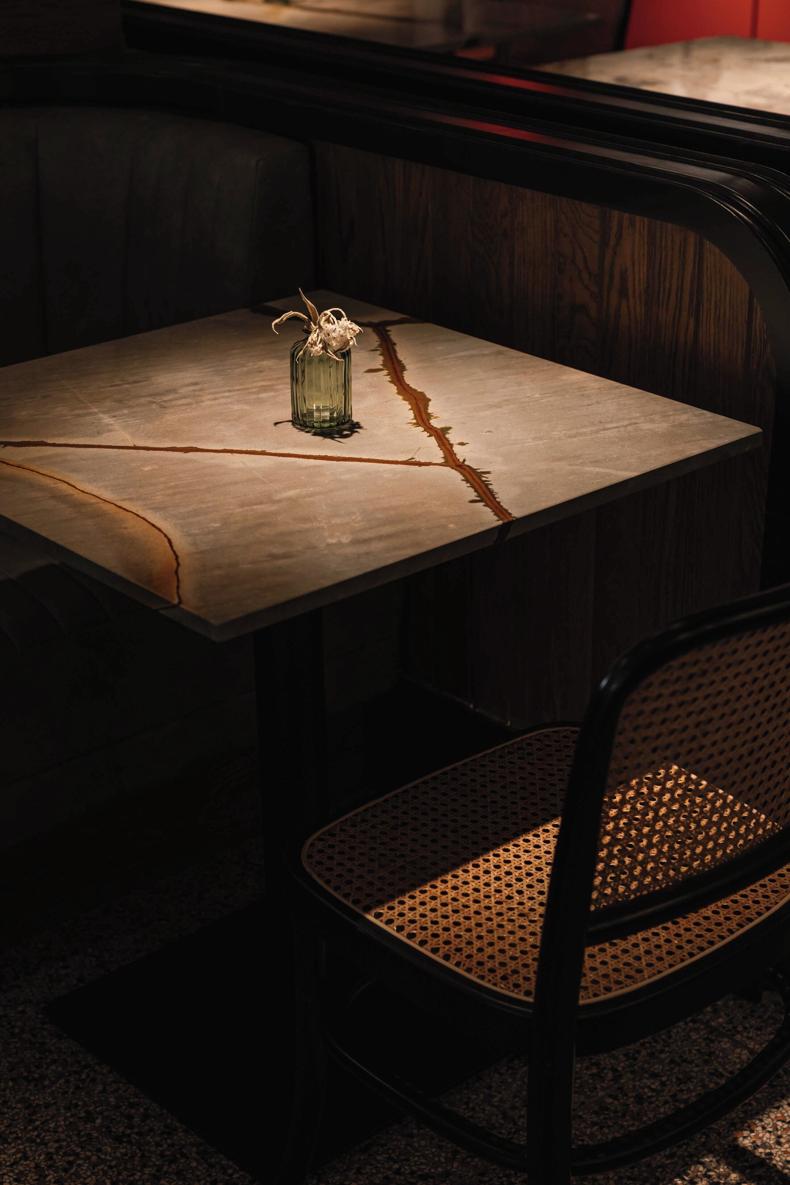 A table with a vase and a chair.