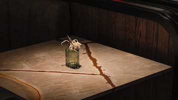 Uma mesa com um vaso e uma cadeira.