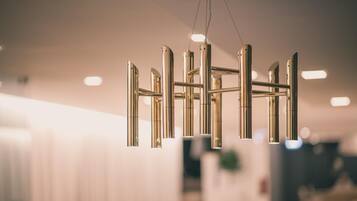 A modern chandelier with multiple arms and hanging lights in a well-lit room.