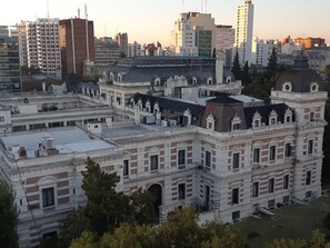 Un edificio histórico con un patio central, rodeado de modernos rascacielos.
