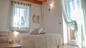 A bedroom with a wooden ceiling, a bed with white bedding, a bedside lamp, and a window with sheer curtains. - Antica Residenza de Poda (Contà)
