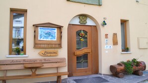 A building with a wooden door labeled "Ospitalità," a wooden bench with a sign "Antica Residenza de Poda," and a wooden sign indicating "Parking." - Antica Residenza de Poda (Contà)