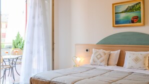 A bedroom with a bed, a nightstand, a painting, and a view of the outdoors. - Antica Residenza de Poda (Contà)