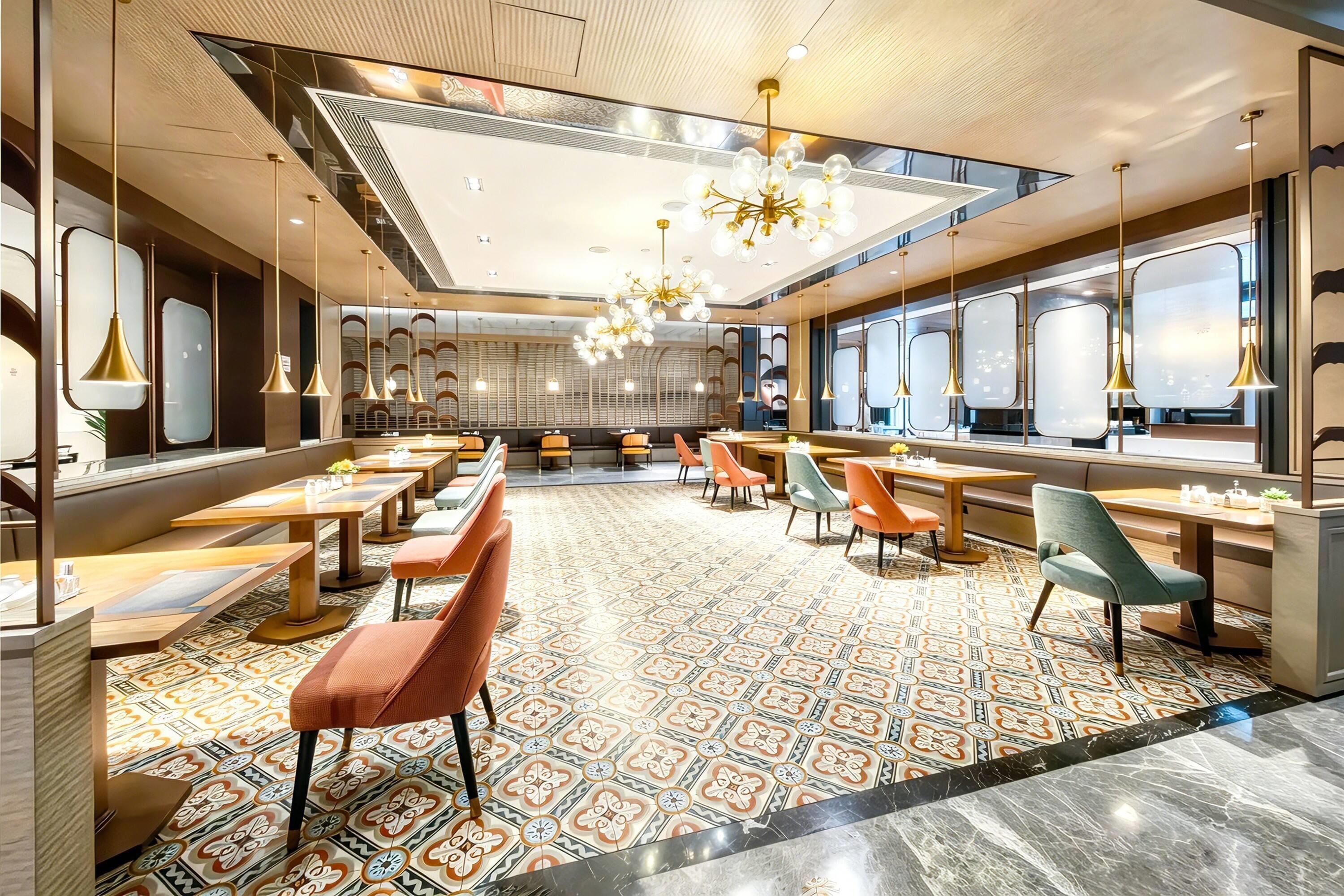 Un restaurante moderno con suelo estampado, varias mesas y sillas.