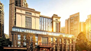 A modern hotel with a traditional facade, large windows, and a prominent entrance. - Ramada Leshan (Leshan)