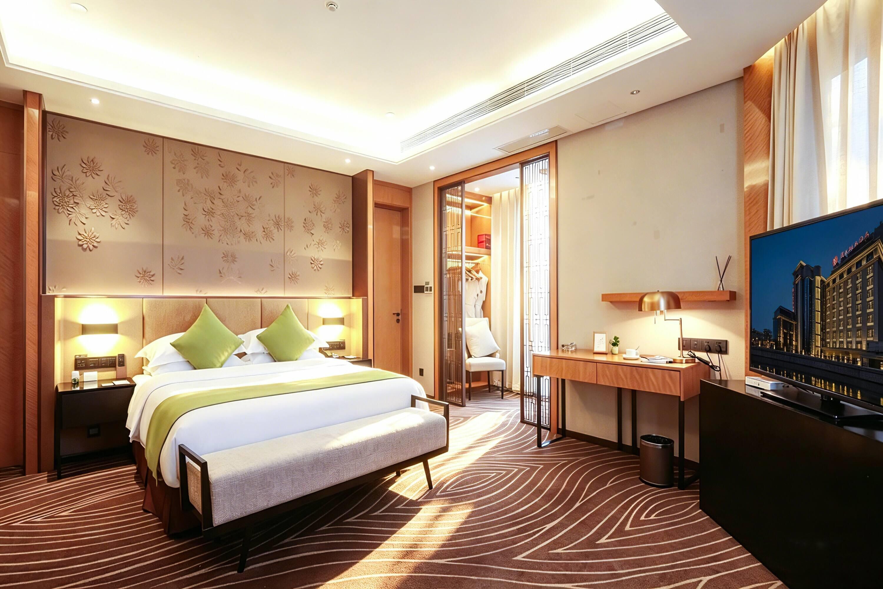 Een hotelkamer met een bed, bureau en een schilderij van een gebouw.