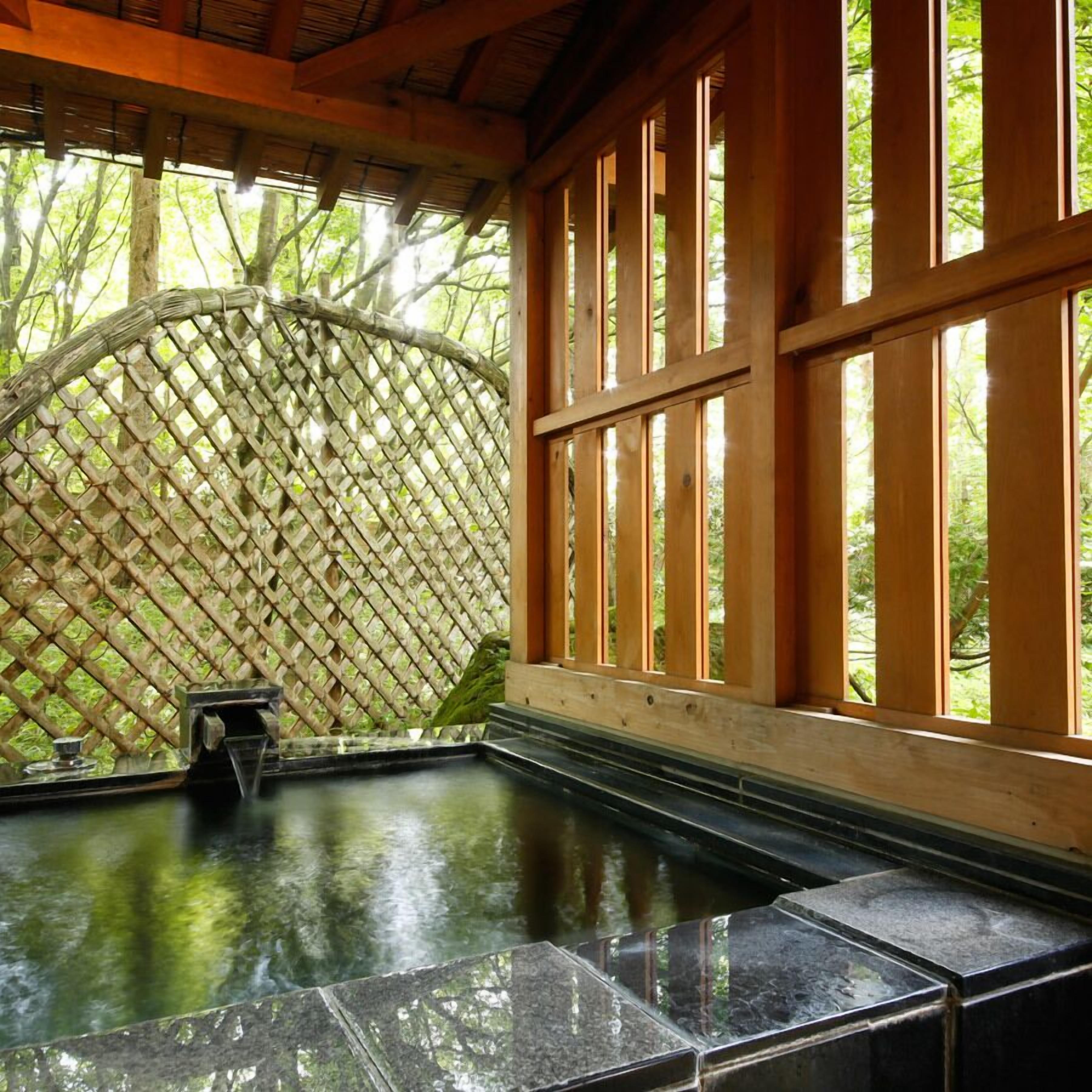 A hot tub area with a wooden lattice wall and large windows.