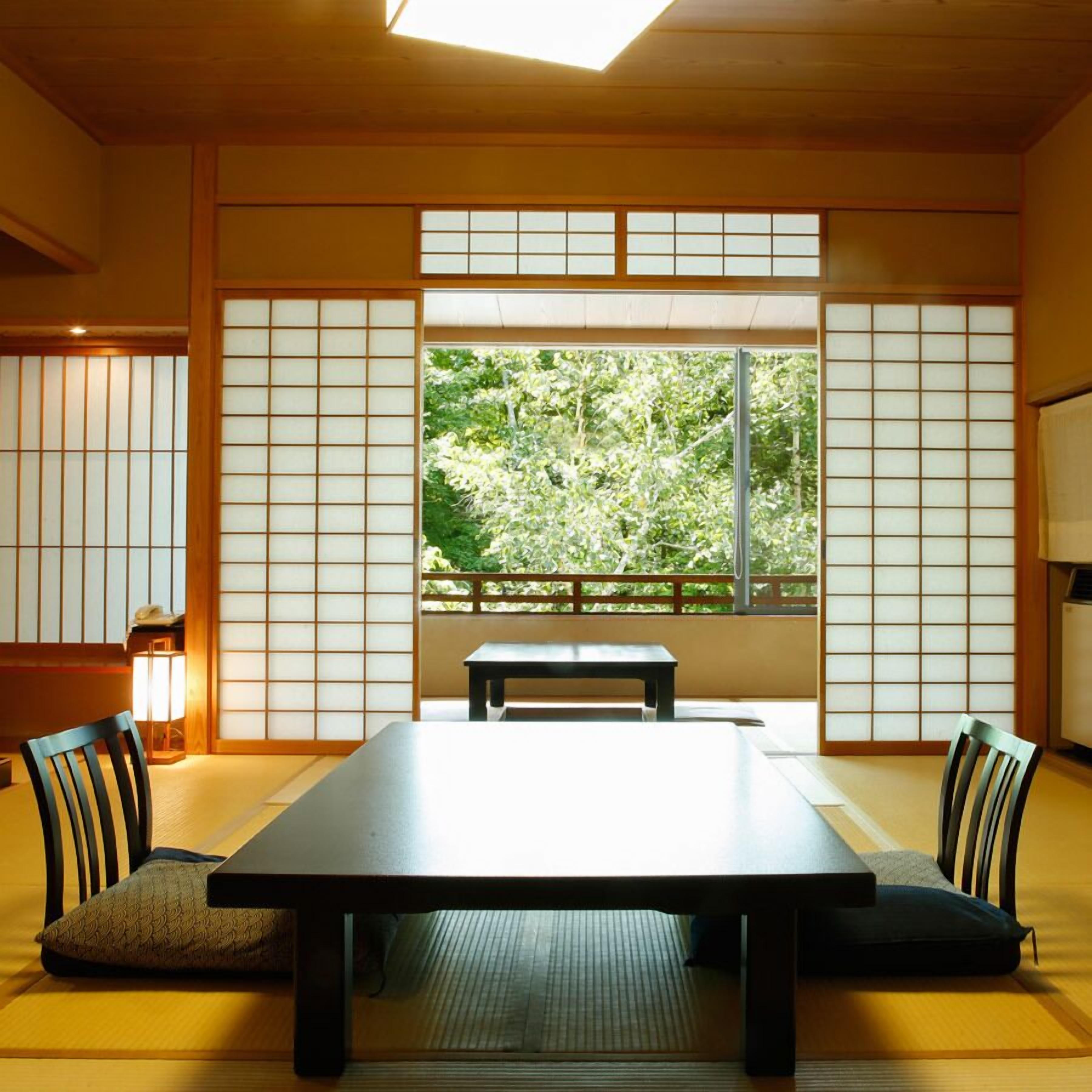 Een traditionele Japanse kamer met tatami vloerbedekking, een lage tafel en shoji schermen.