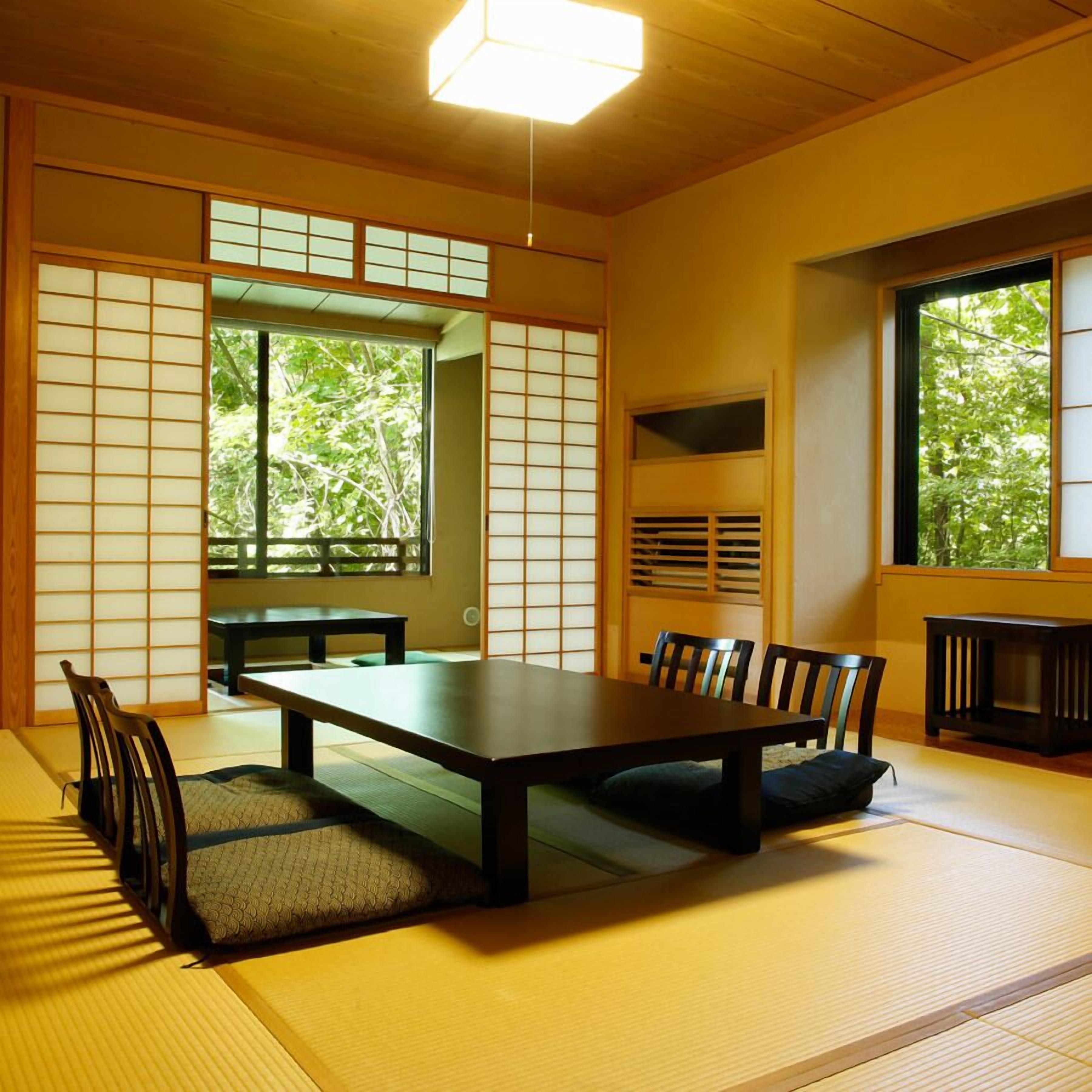 A traditional Japanese room with tatami flooring, a low table, and sliding doors.