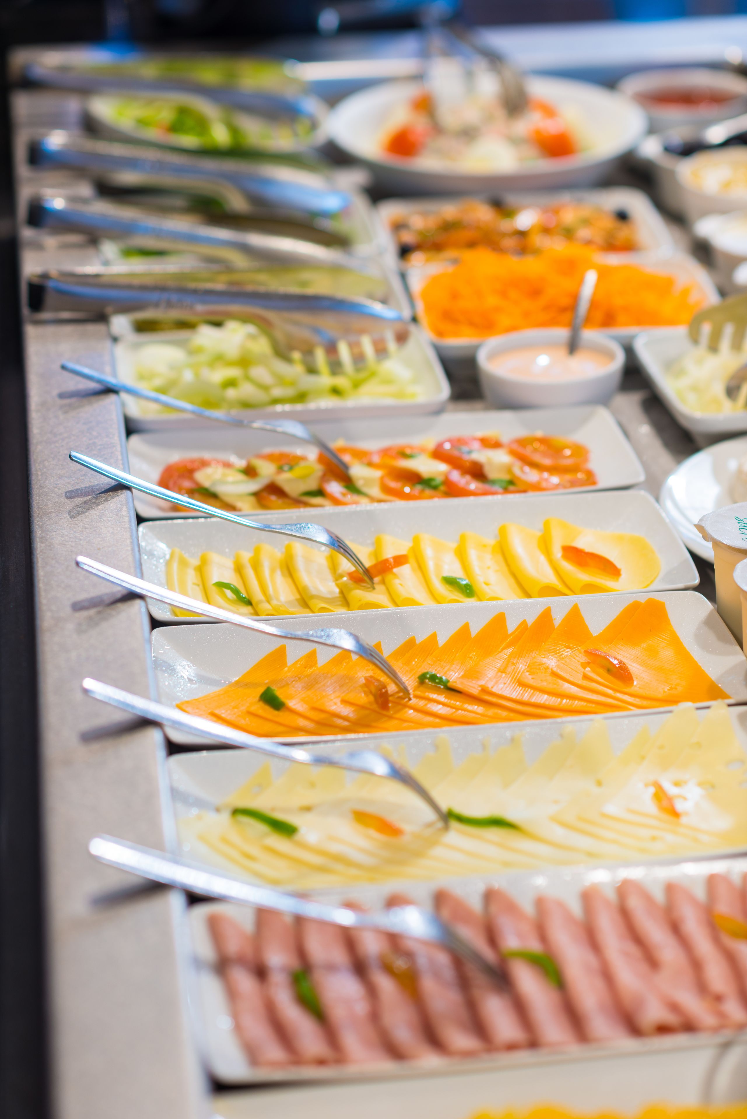 A buffet with various food items and utensils.