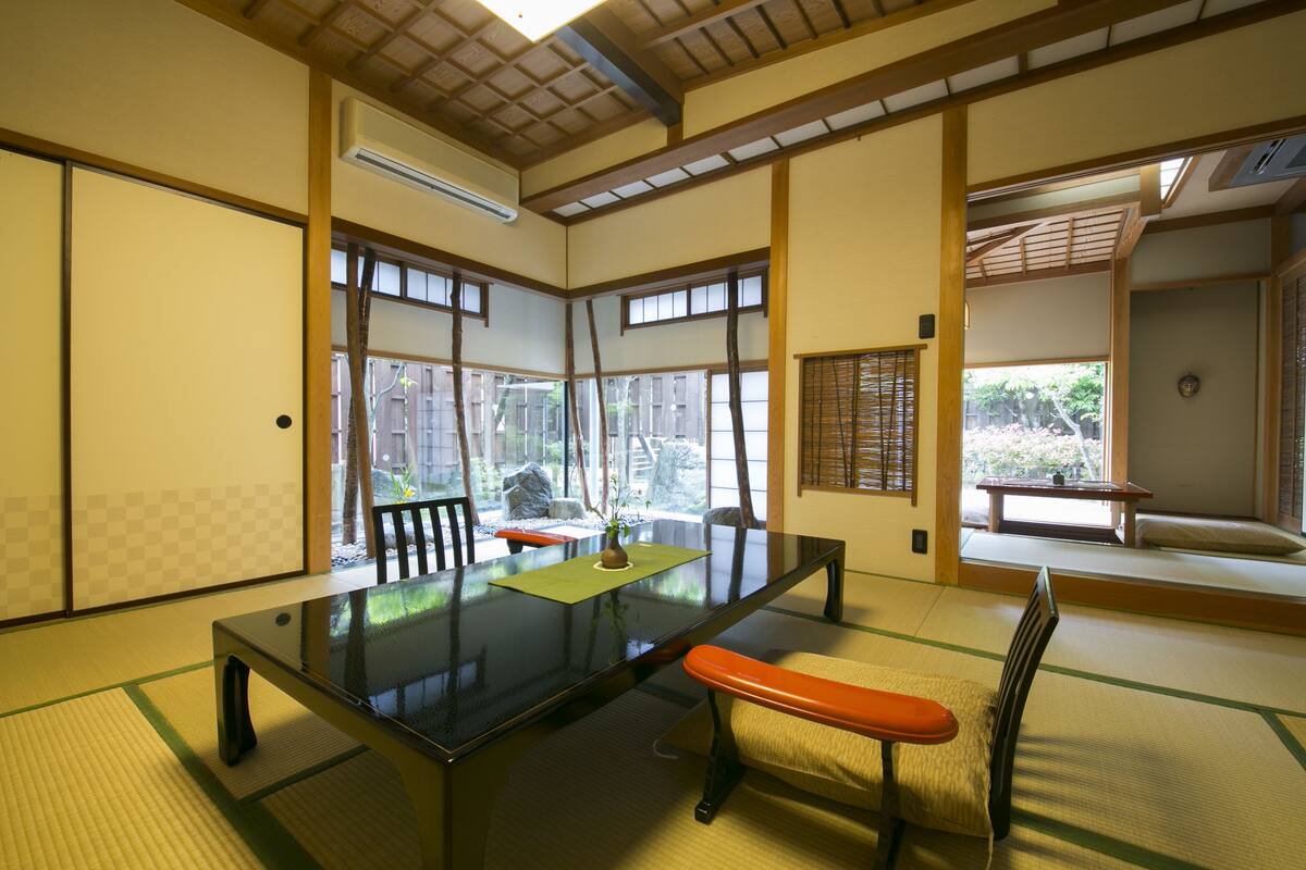 Ein traditioneller japanischer Raum mit Tatami-Boden, einem niedrigen Tisch und Schiebetüren.
