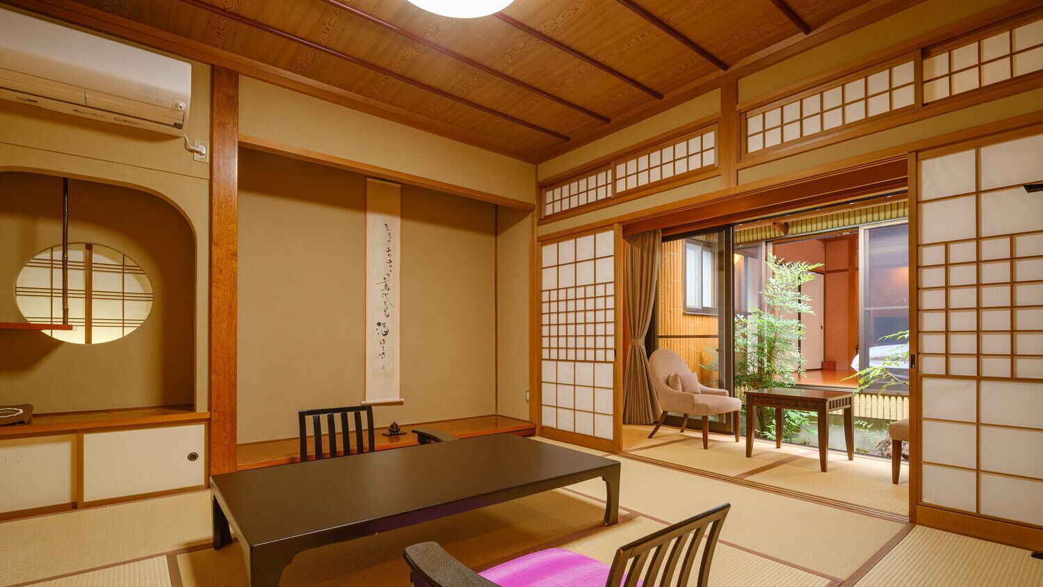 A traditional Japanese room with tatami flooring, a low table, and sliding doors.