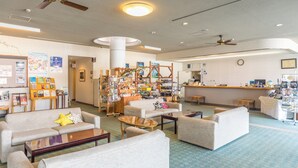 A spacious lobby with multiple seating areas, a reception desk, and a variety of displayed items.