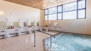 A large indoor swimming pool with multiple shower areas and mirrors.