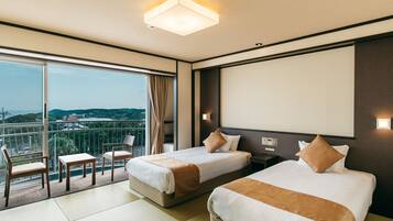 Habitación de hotel con dos camas, un balcón y un ventanal grande que ofrece vistas de la ciudad.
