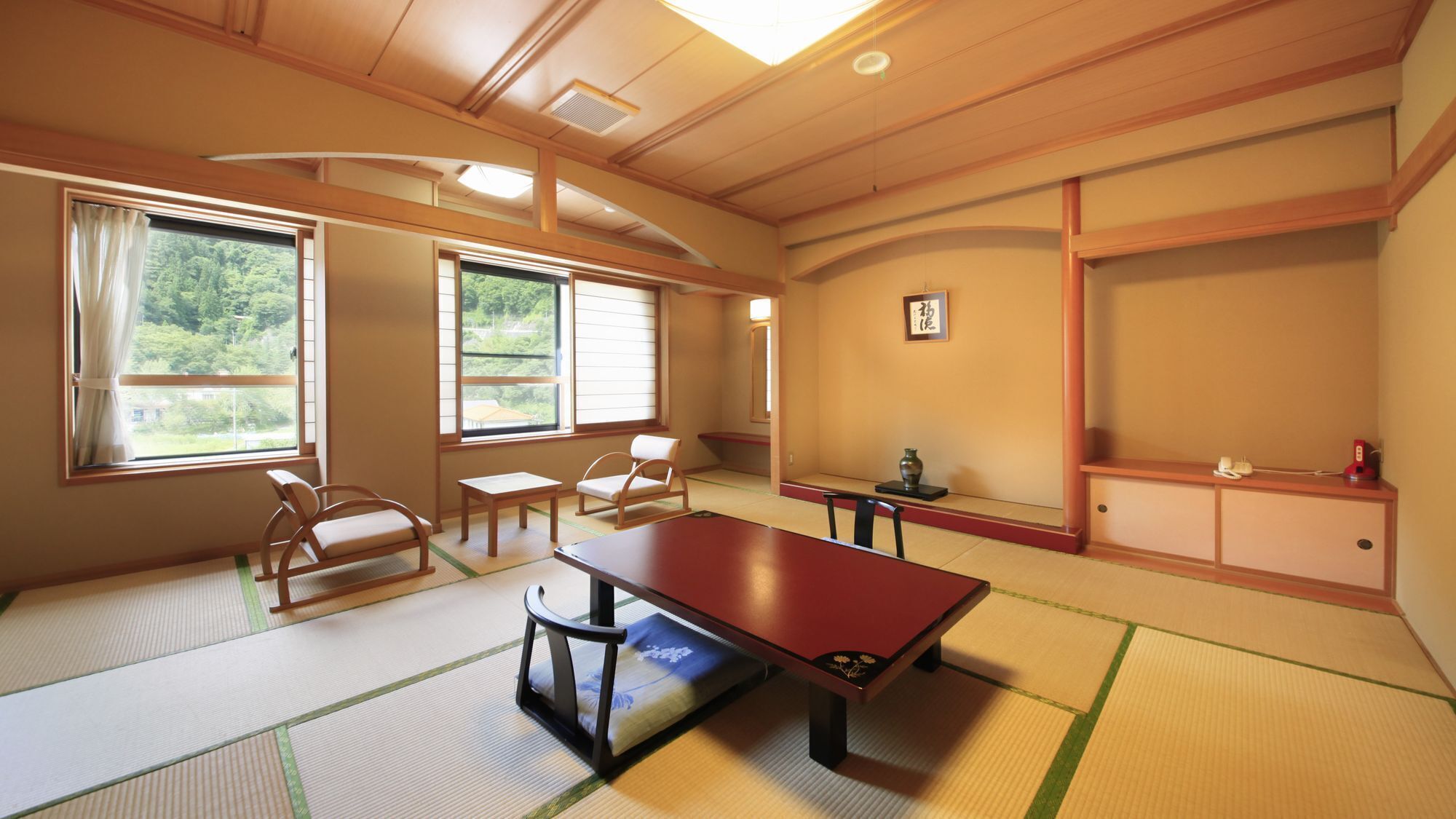 Una habitación tradicional japonesa con suelo de tatami, una mesa baja y puertas correderas.