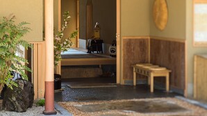 Una habitación tradicional japonesa con suelo de tatami, una mesa de madera baja y una puerta corredera de shoji.