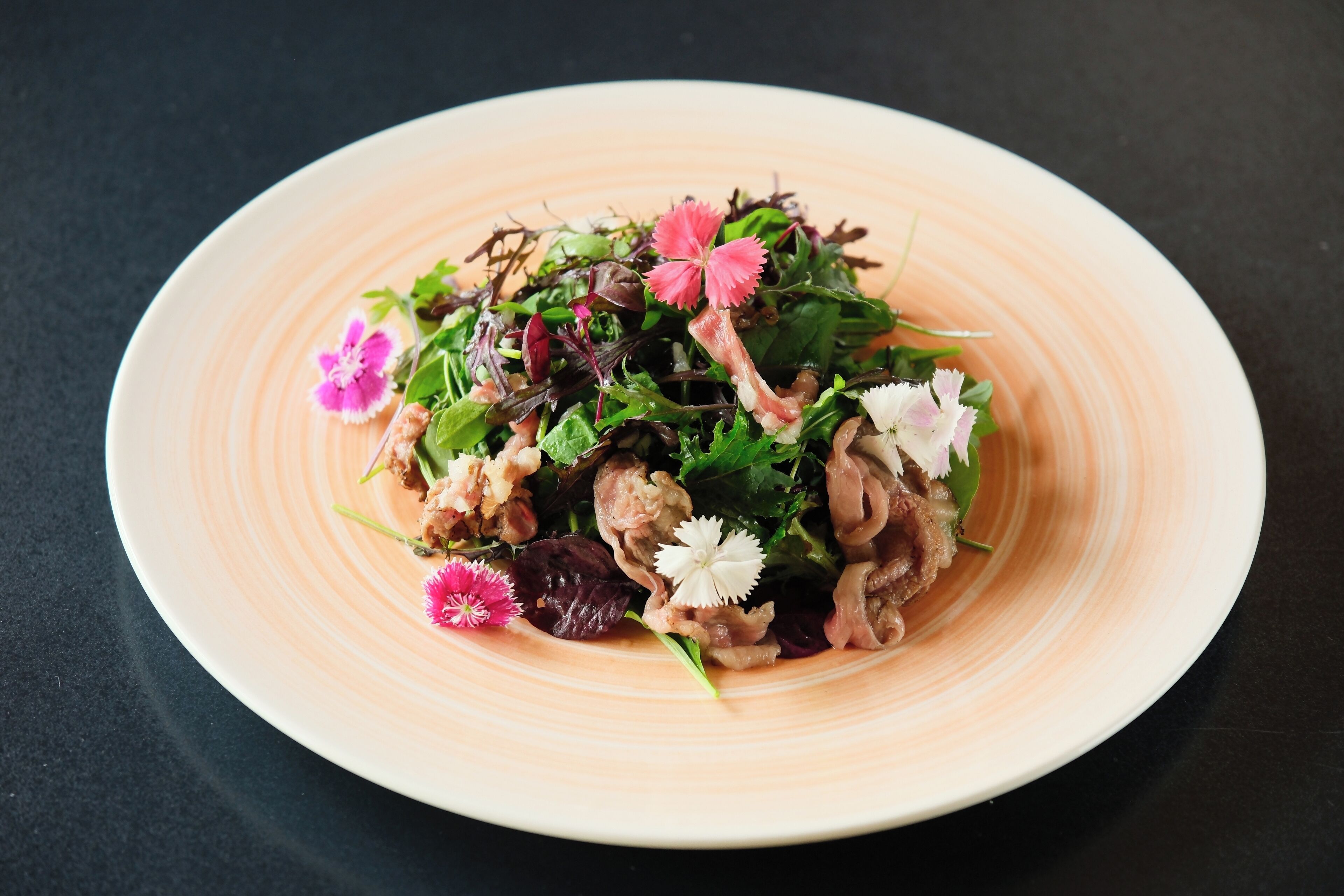 Une assiette de nourriture comprenant différentes sortes de légumes verts et de fleurs.
