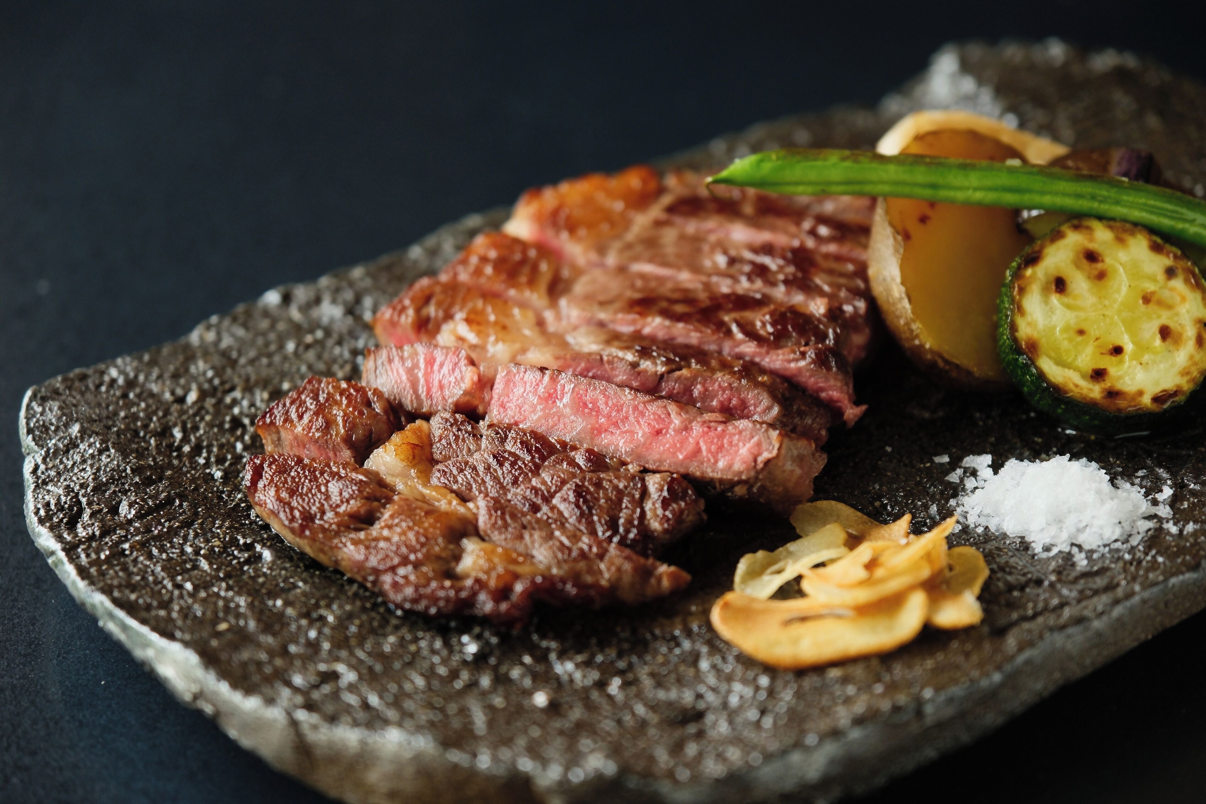 Un plato de piedra con carne y verduras.