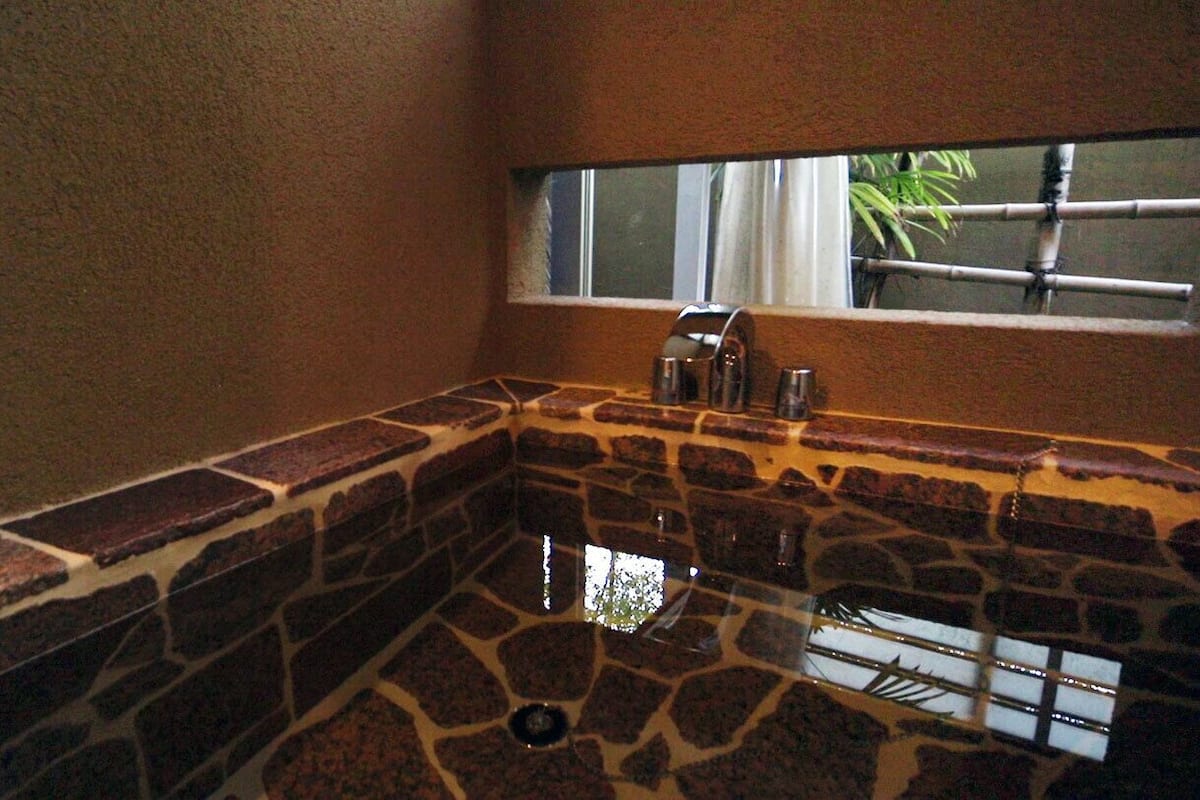A stone bathtub with a window above it.