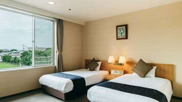 A hotel room with two beds, a large window, a nightstand with lamps, and a framed picture on the wall.