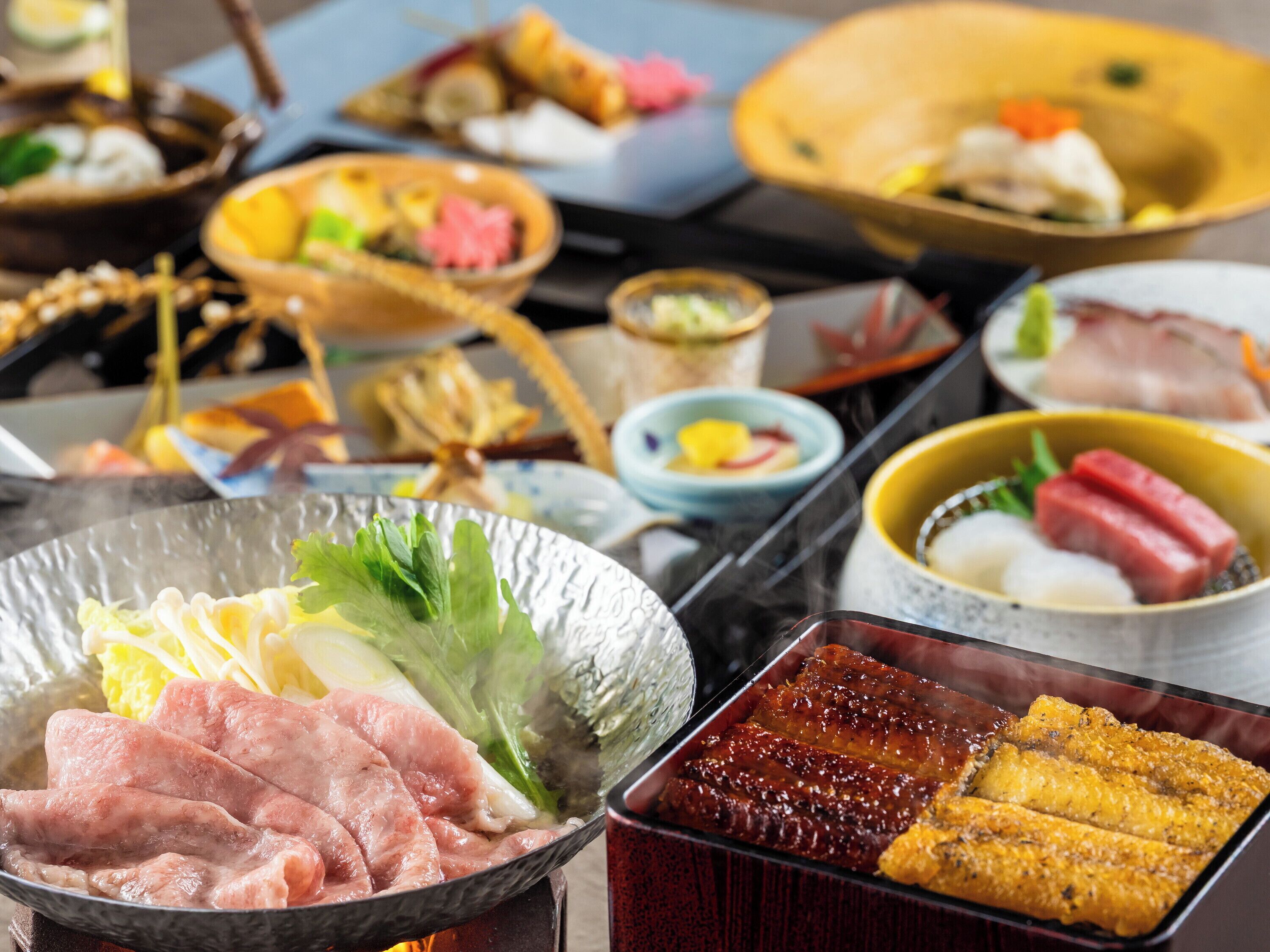 A variety of dishes including meat, vegetables, and possibly seafood, arranged on a table.