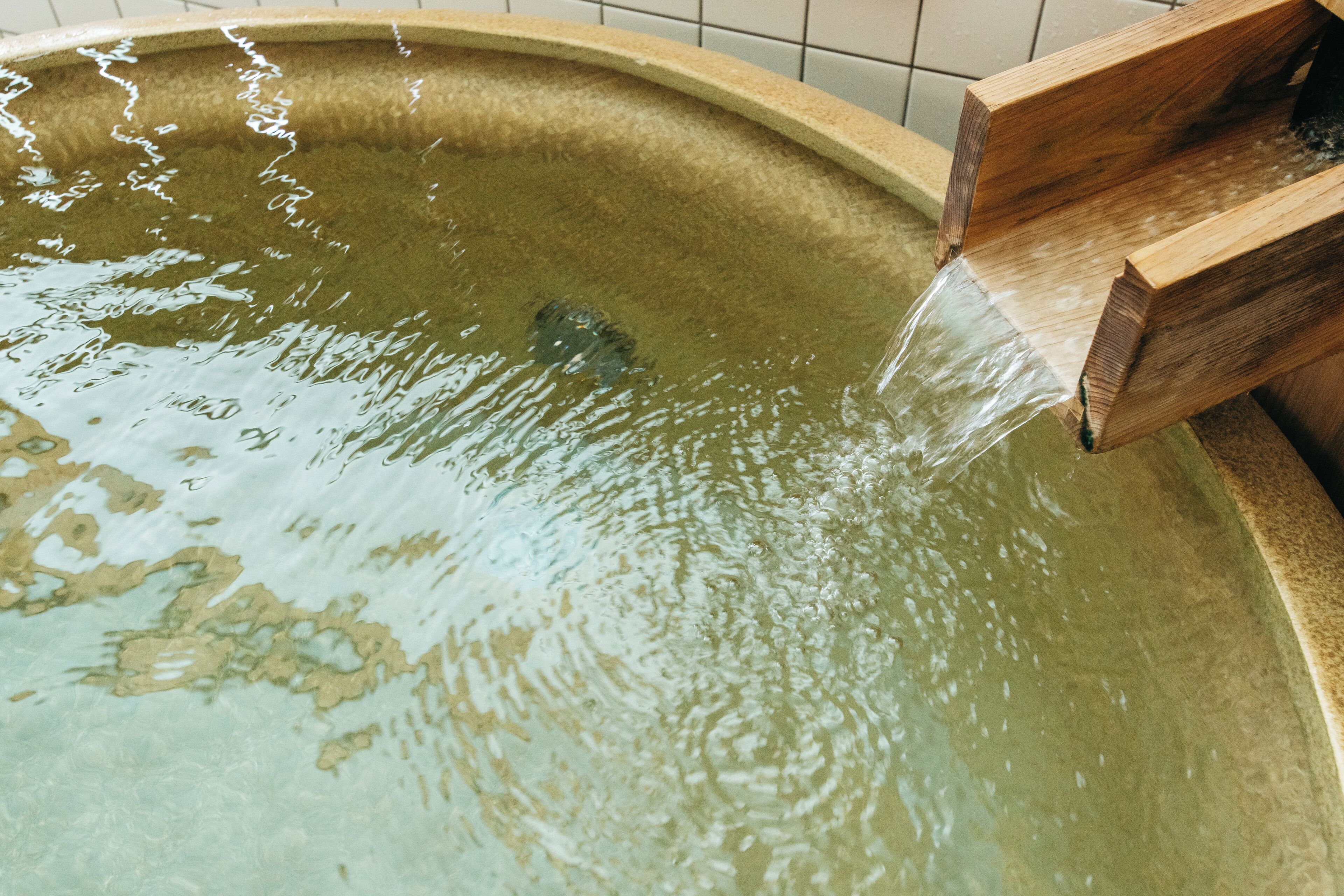 A wooden bath with water flowing into it.