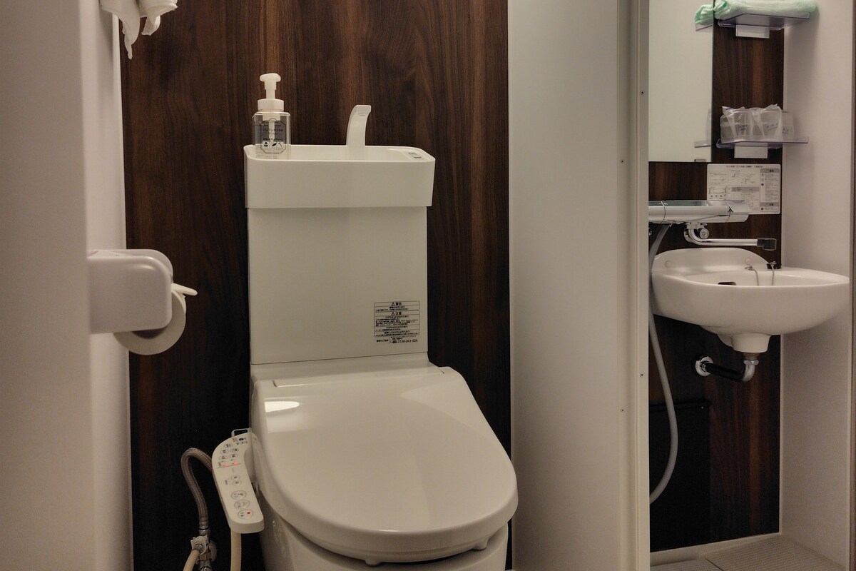 A modern bathroom with a toilet, a sink, and a mirror.