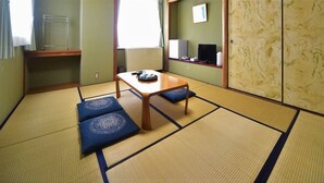 Een traditionele Japanse kamer met tatami vloerbedekking, een lage houten tafel en kussens.