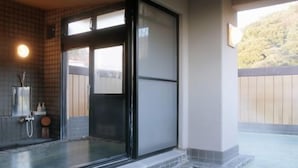 Área de spa com hidromassagem em vidro, chuveiro e vista para o exterior.