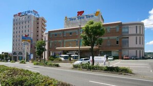 A hotel with a large sign reading 'You You You' and a smaller sign for 'SoftBank.' - Hotel Peaceful (Kumamoto)