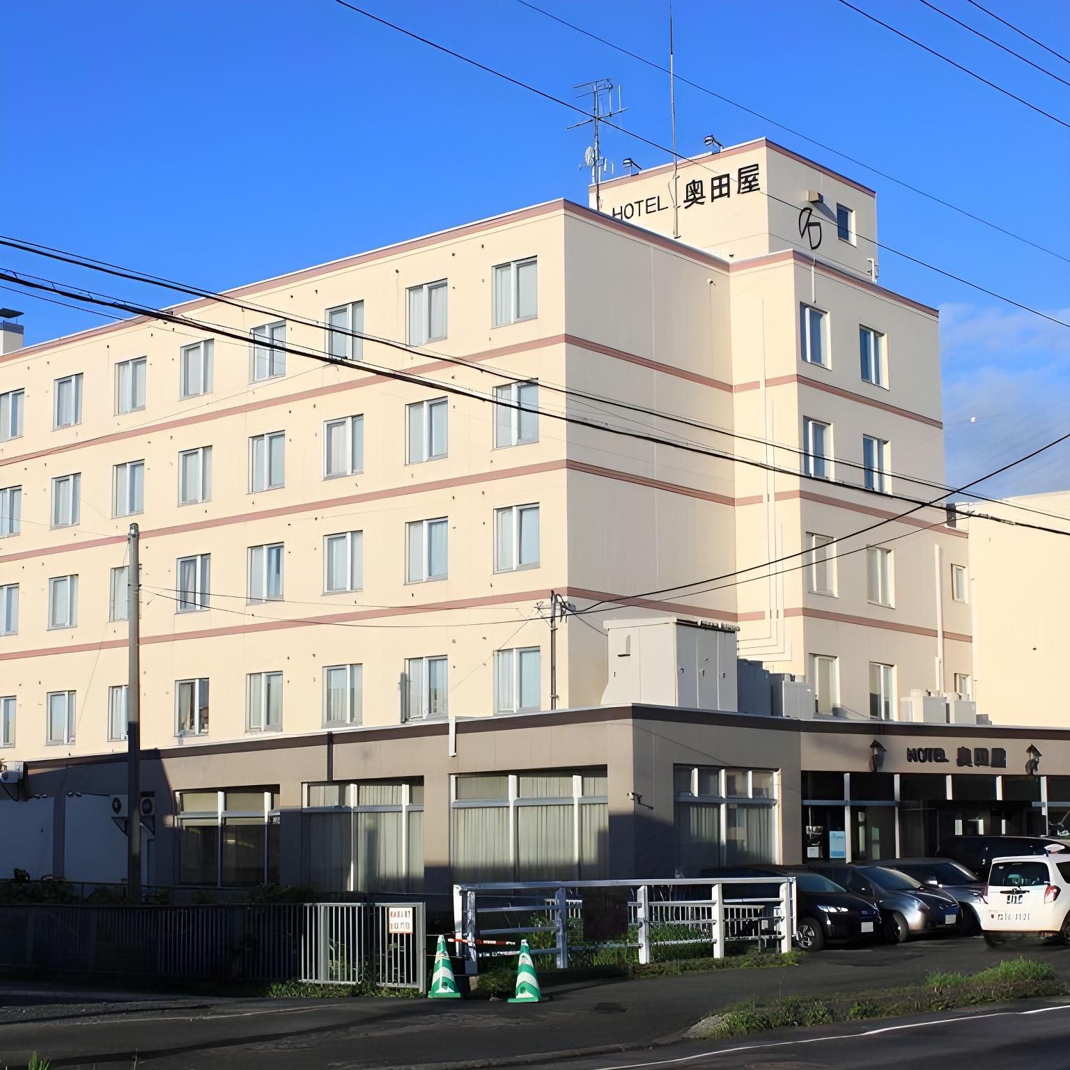 A multi-story hotel with a flat facade, numerous windows, and a sign indicating it is a hotel.