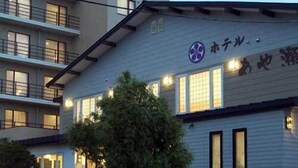 A building with a sign that reads 'ホテル' and a logo with a flower. - Hotel Ayase (Rishifuji)