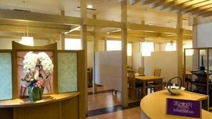 A reception area with a curved counter, a vase of flowers, and a sign that reads 'Information.' - Hotel Ayase (Rishifuji)