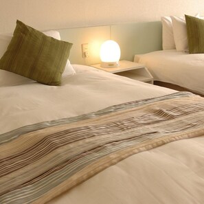 Een hotelkamer met een bed, een bedlamp en een nachtkastje.
