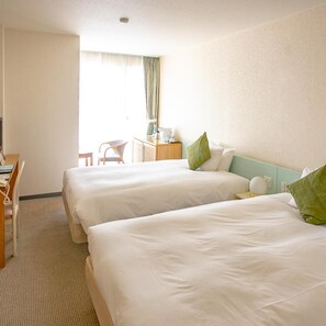 A hotel room with two beds, a desk, a chair, and a window with curtains. - Inubosaki Hotel (Choshi)