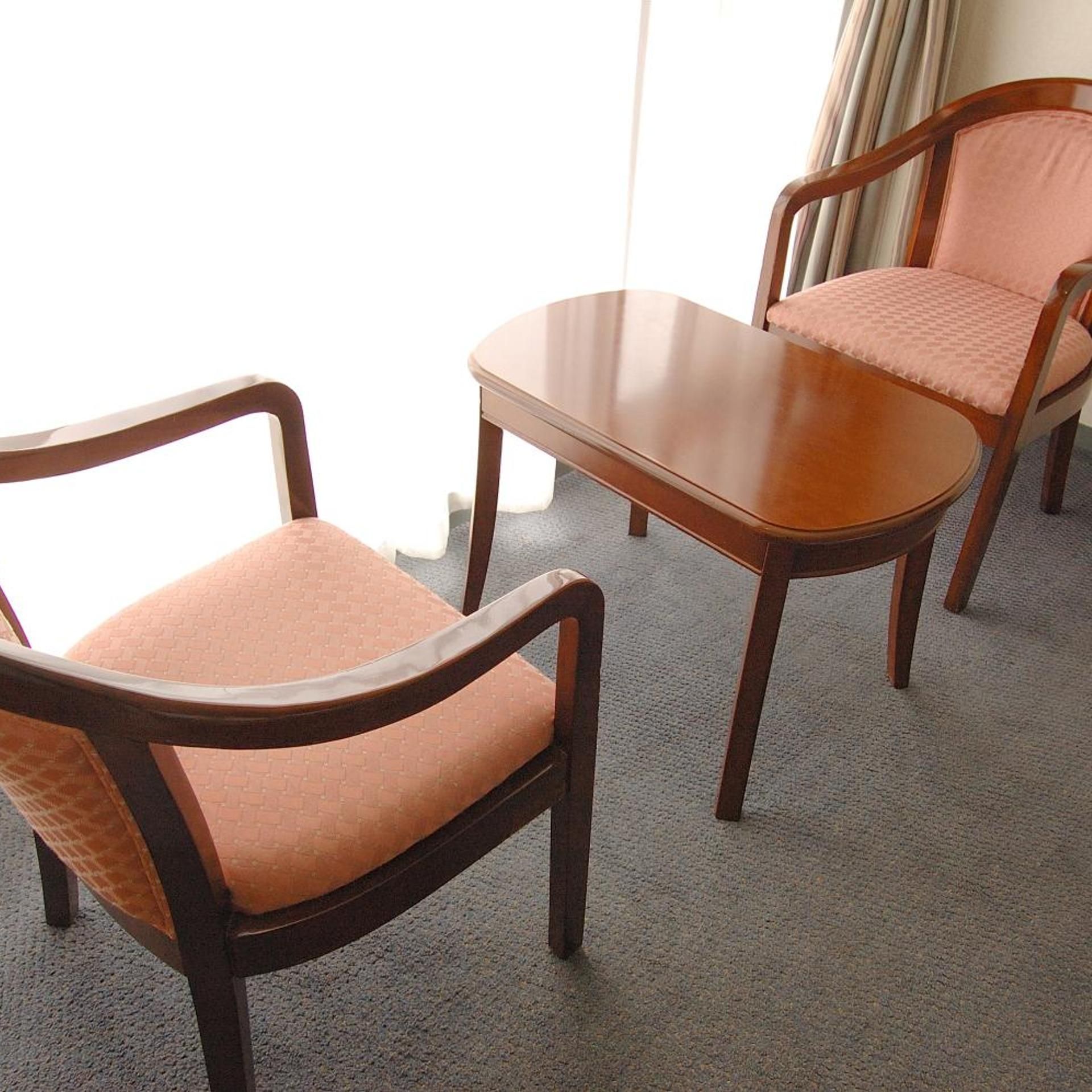 A room with two wooden chairs and a small table.