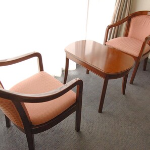 Een kamer met twee houten stoelen en een tafeltje.