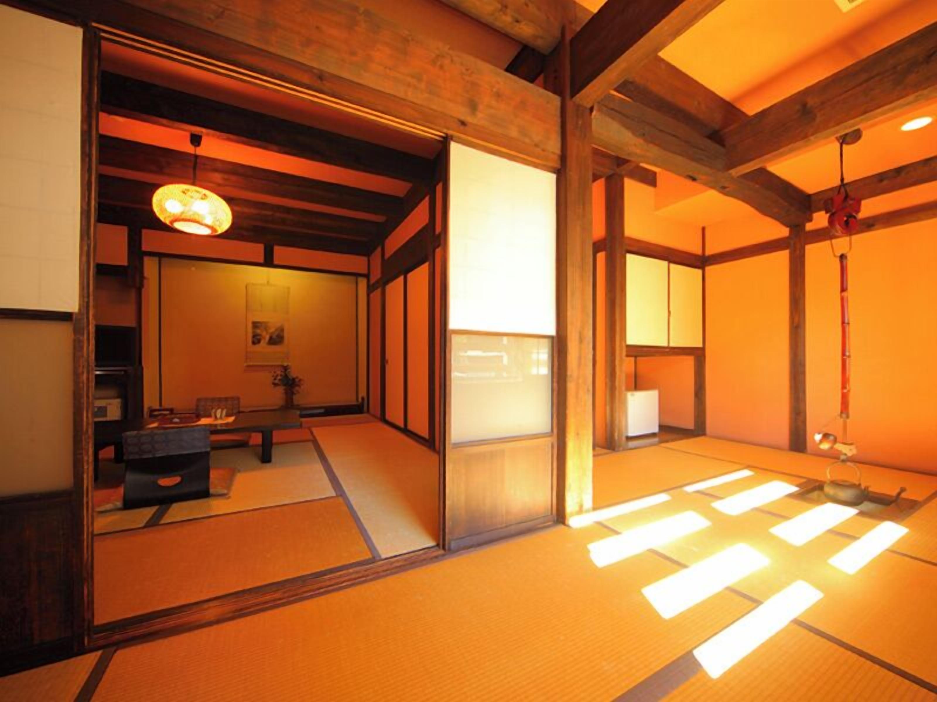 Una habitació japonesa tradicional amb tatami, portes corredisses i un sostre baix amb bigues al descobert.