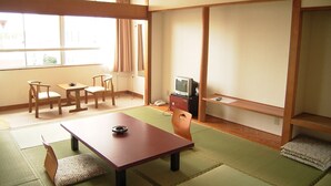 A traditional Japanese room with tatami flooring, a low table, a television, and a sliding door. - Shirako Onsen Sunshine Shirako (Shirako)