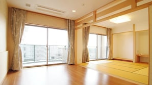 A room with large sliding glass doors, a wooden floor, and a tatami mat area. - Shirako Onsen Sunshine Shirako (Shirako)