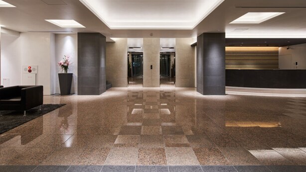 A spacious lobby with a checkered floor, a reception desk, and a large potted plant. - Hotel Royal Garden Kisarazu (Kisarazu)