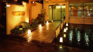 Entrada de hotel con una galería techada, un mostrador de recepción y un acceso mediante portón.