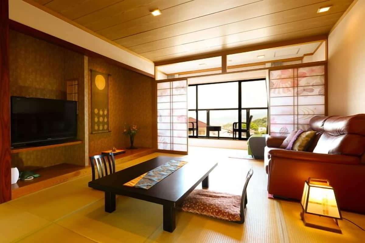Un saló tradicional japonès amb tatami, una taula baixa, un sofà i una televisió.