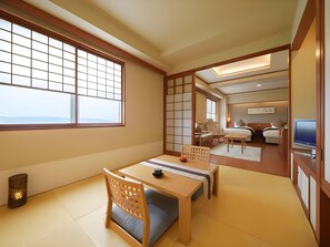 A traditional Japanese-style room with tatami flooring, a low table with cushions, and sliding doors. - Hotel Meguma (Wakkanai)