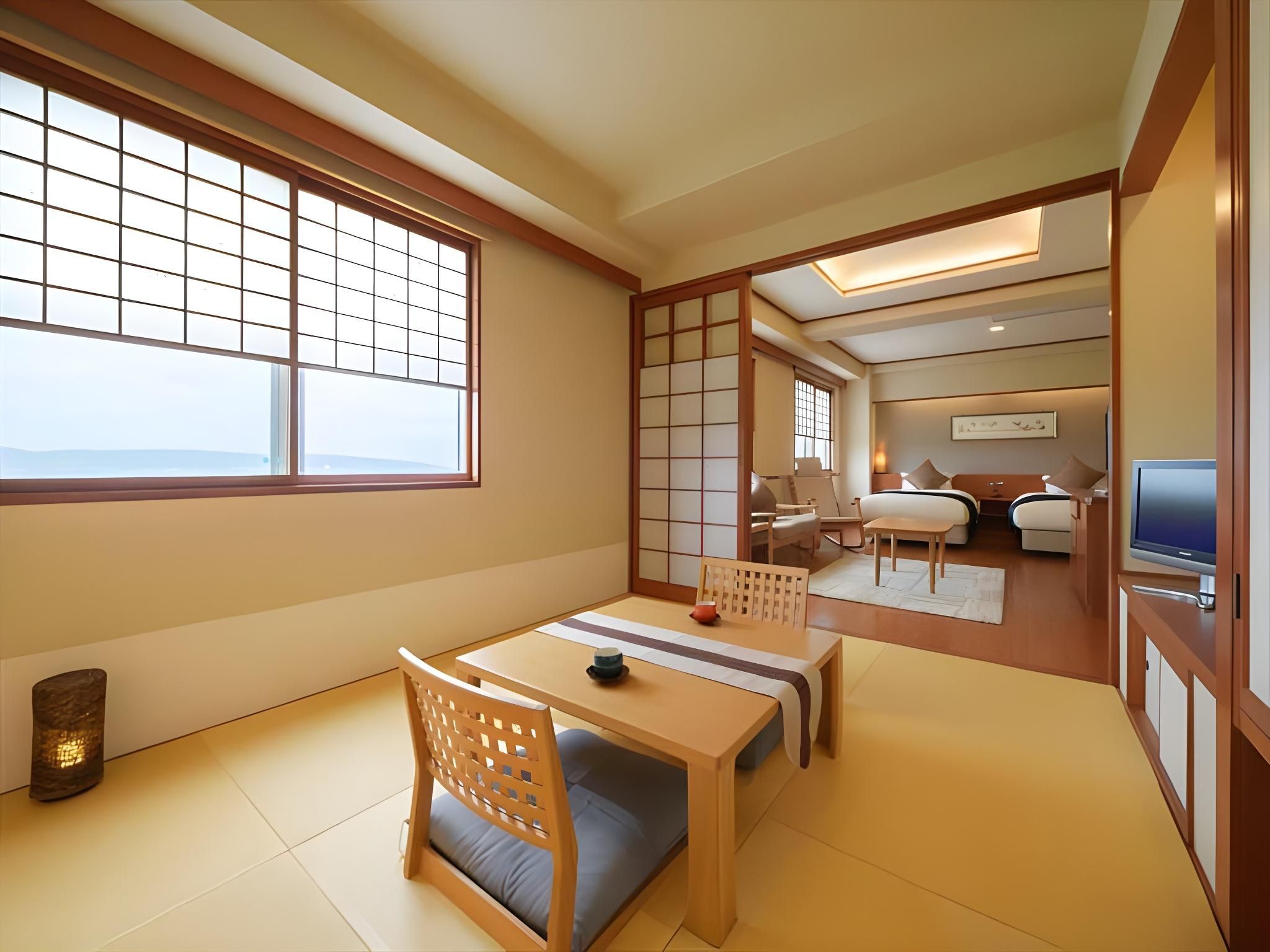 A traditional Japanese-style room with tatami flooring, a low table with cushions, and sliding doors.