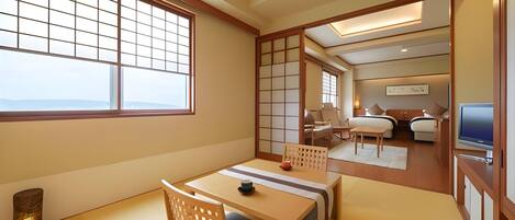 A traditional Japanese-style room with tatami flooring, a low table with cushions, and sliding doors.