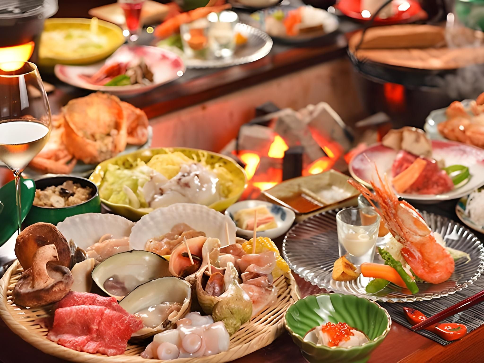 Diversos platos de mariscos y bebidas sobre una mesa, con un fuego encendido al fondo.